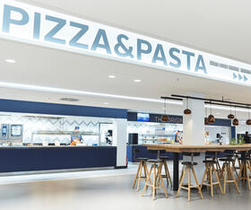 Pizza- und Pasta-Ausgabe mit Tischen und Stühlen in der Elbe-Kantine bei Otto