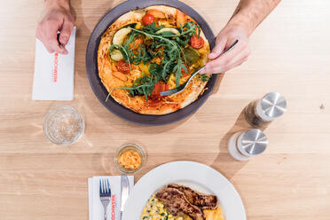 Auf dem Tisch sind zwei Teller mit großen Portionen Essen zusehen.