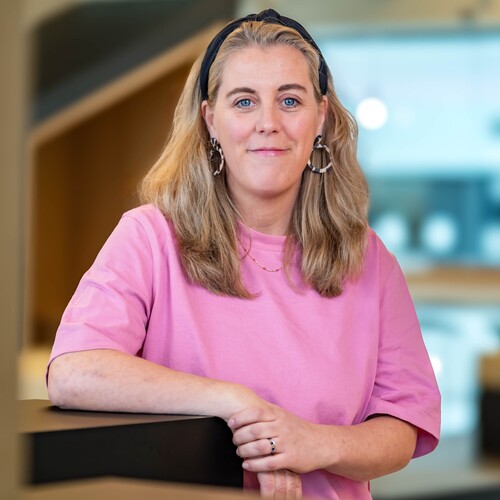 Hannah, Recruiterin bei OTTO, im Social Space auf dem OTTO Campus und lächelt in die Kamera.