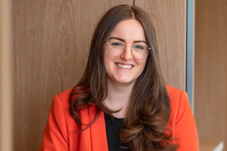 Michelle, Recruiterin bei OTTO, sitzt lächelnd im Social Space auf dem OTTO Campus