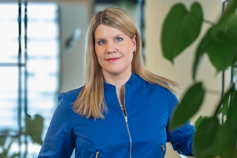 Ann-Kathrin, HR Managerin Recruitment Marketing &amp; Sales, steht im Social Space und lächelt freundlich