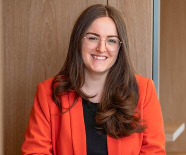 Michelle, Recruiterin bei OTTO, sitzt lächelnd im Social Space auf dem OTTO Campus