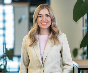 Sophia, Recruiterin bei OTTO, steht im Social Space auf dem OTTO Campus und lächelt freundlich in die Kamera