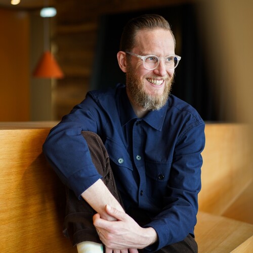 UX-Designer sitz auf einer Holzbank Unser UX-Designer sitzt lässig in lockerer Haltung und guckt zur Seite