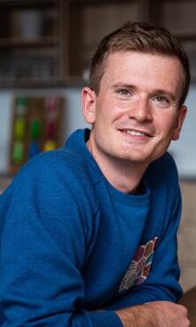 Unser Kollege Lead Product Manager Apps lehnt sich auf den Tisch Unser Kollege Lead Product Manager Apps lehnt sich auf den Tisch