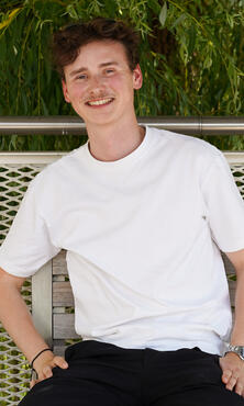 Unser Kollege im Advertising Team sitzt auf einer Bank