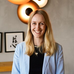 Duale Studentin Business Administration bei OTTO steht lächelnd vor der Kamera.