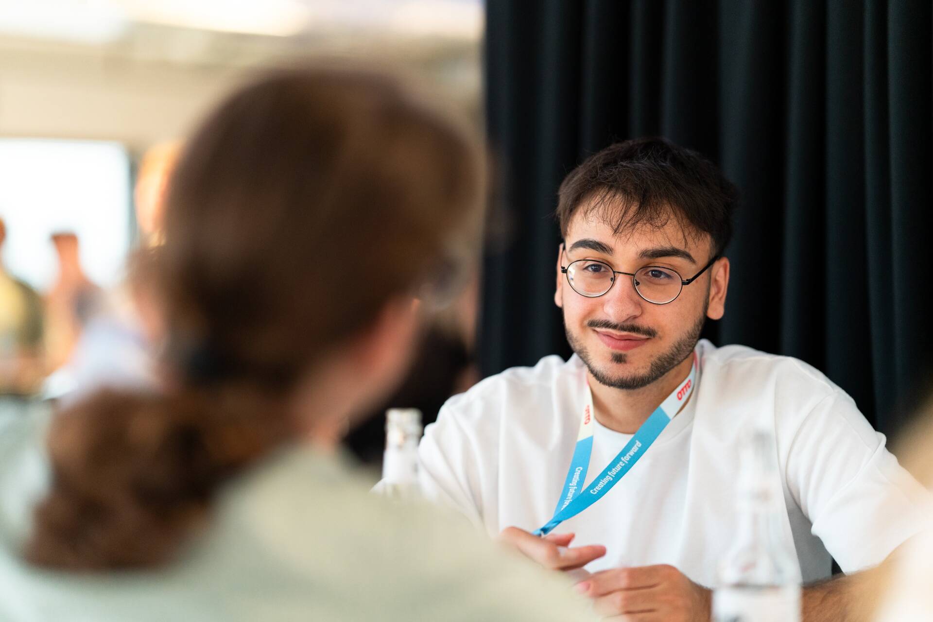 Während der Starter Days 2025 unterhält sich der dual studierende Fachinformatiker aufmerksam mit einer anderen Kollegin. 