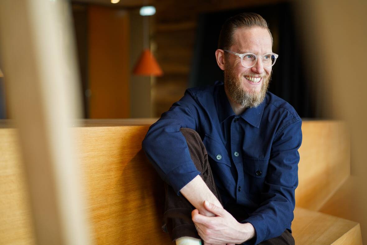 Unser UX-Designer sitzt lässig in lockerer Haltung und guckt zur Seite