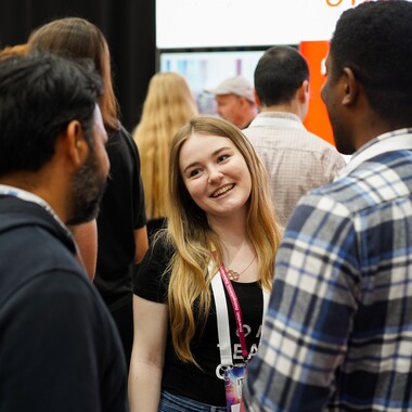 Junior HR Managerin ITCS 2023 Junior HR Managerin ist auf der ITCS Messe 2023 und unterhält sich mit anderen Besuchern.