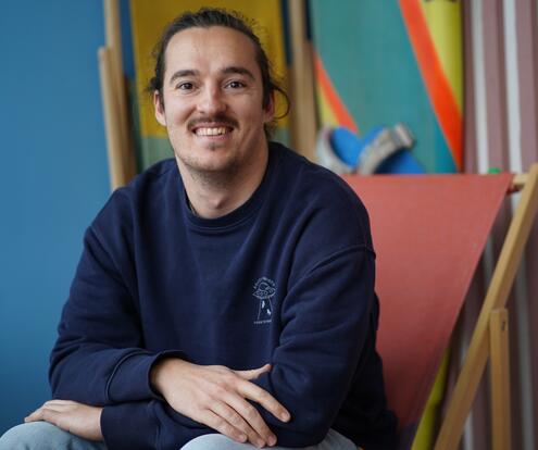 Software-Entwickler und Workation-Liebhaber Software-Entwickler und Workation-Liebhaber sitzt in einer lockeren Haltung auf einem Liegestuhl.