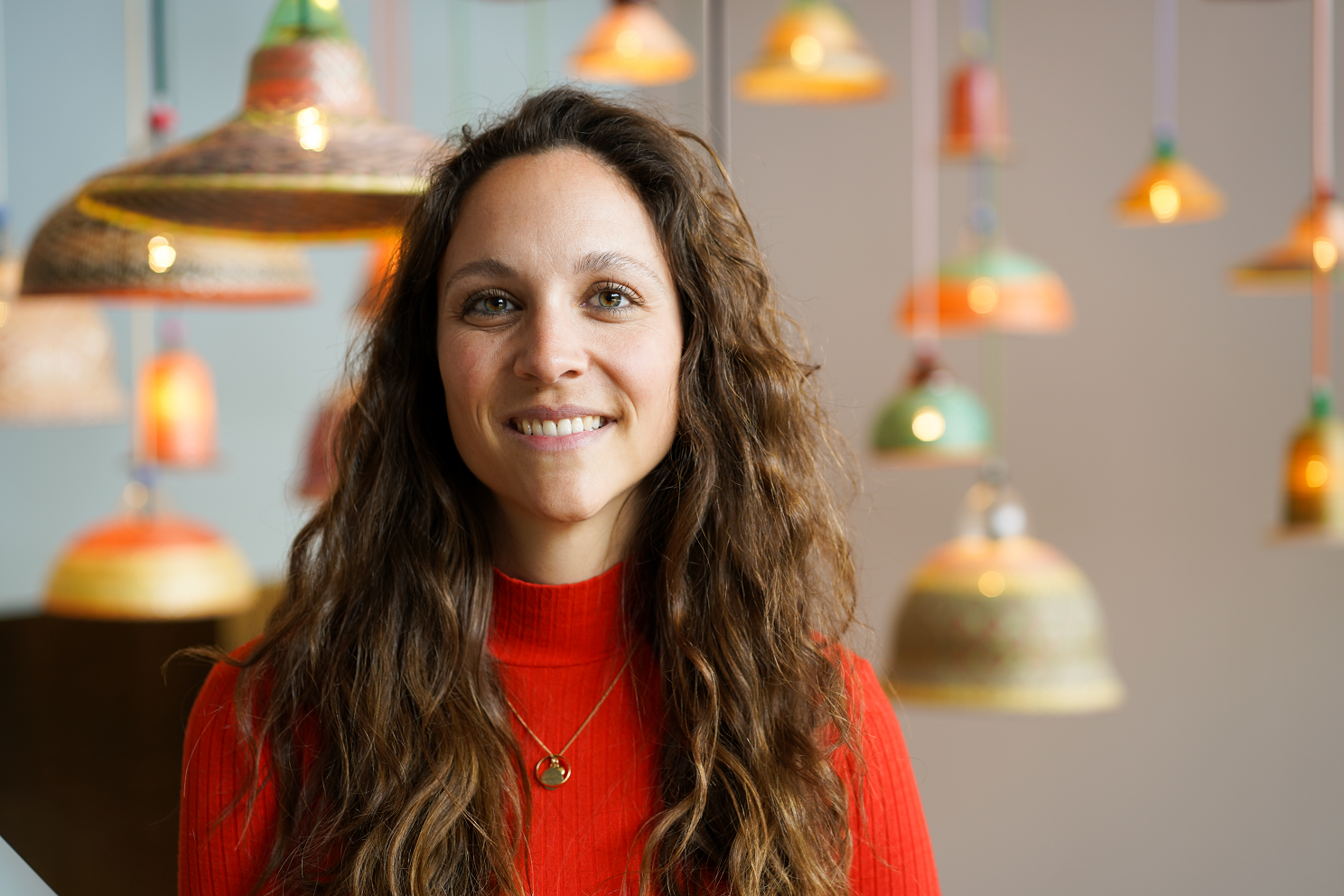 Product Owner Campus IT Services ist Teil der ersten Staffel Role Models in Tech. Sie lächelt in die Kamera und im Hintergrund sind viele Deckenlampen zu sehen.