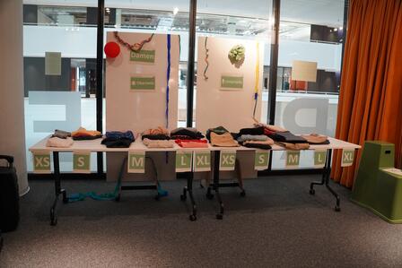Ein Tisch voller Kleidung, die bei einer Kleidertauschparty weitergegeben wird.