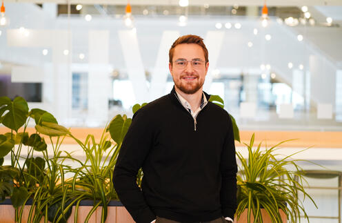 Unser Kollege steht vor mehreren Pflanzen und lächelt in die Kamera Unser Kollege steht vor mehreren Pflanzen und lächelt in die Kamera