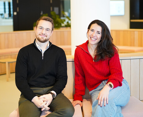 Zwei Kollegen lächeln in die Kamera