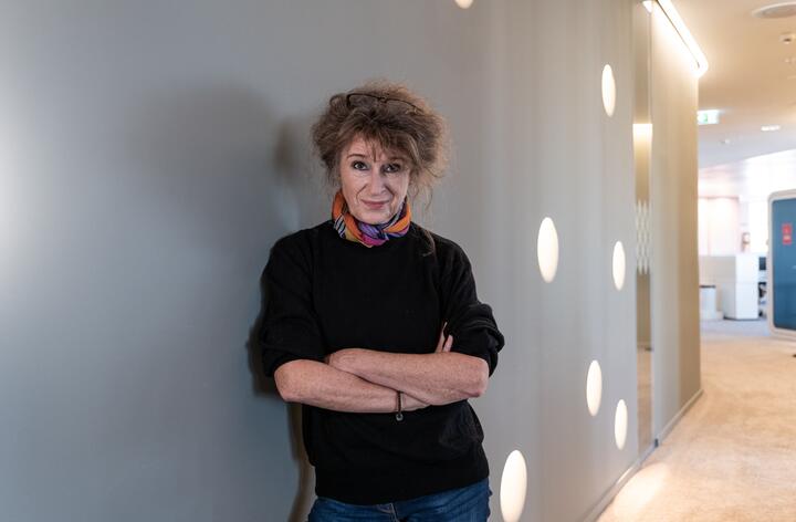 Unsere Kollegin lehnt sich an einer Wand an mit verschränkt die Armen Unsere Kollegin lehnt sich an einer Wand an mit verschränkt die Armen