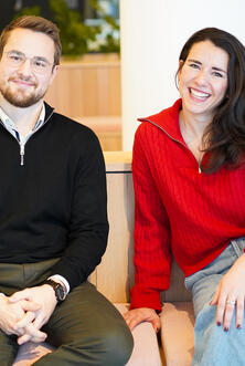 Zwei Kollegen lächeln in die Kamera